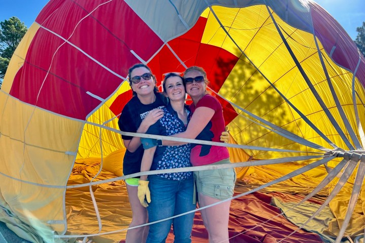 a group of women smiling for the camera while setting up their hot air balloon with pagosa adventure in pagosa springs, colorado