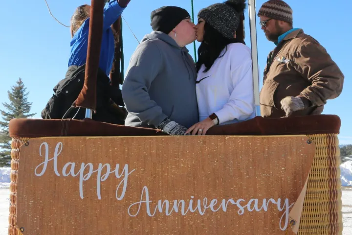 a couple kissing while celebrating their anniversary on pagosa adventure's hot air balloon in pagosa springs, colorado
