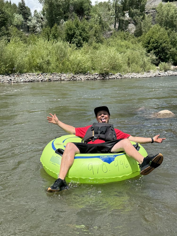 a young man riding a Tube on the San Juan River