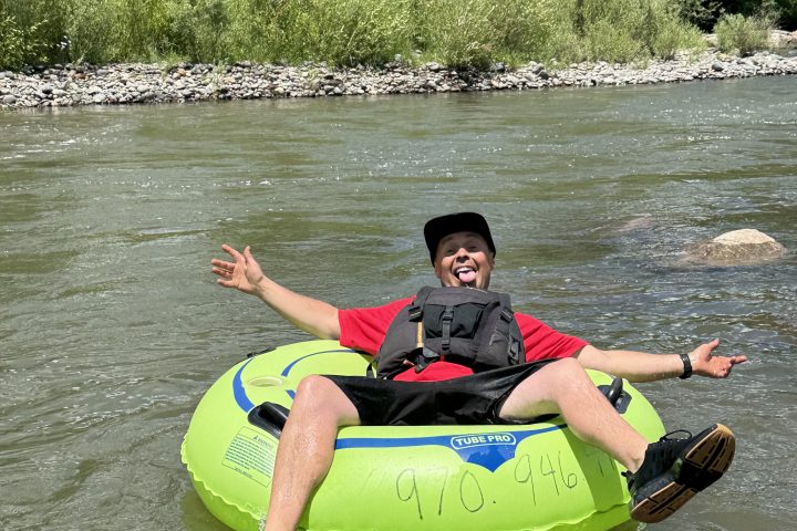 a young man riding a Tube on the San Juan River