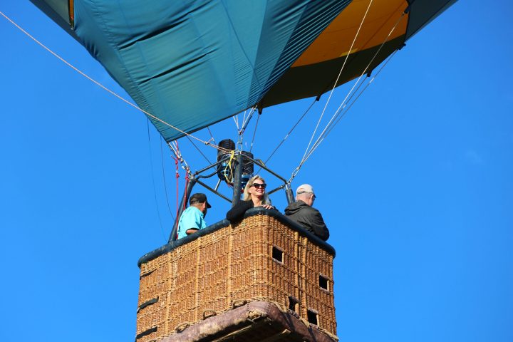 a woman smiling to the camera on board pagosa adventure's hot air balloon in pagosa springs, colorado
