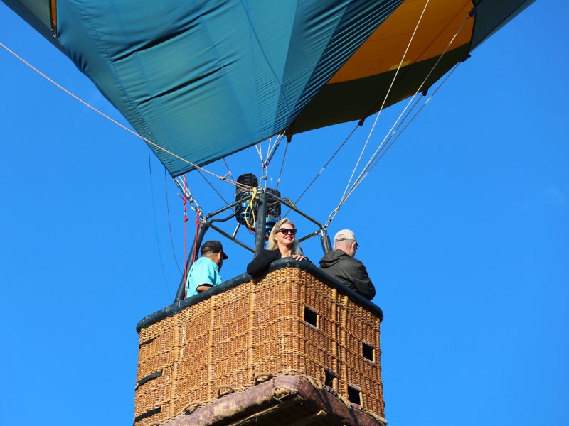 a woman smiling to the camera on board pagosa adventure's hot air balloon in pagosa springs, colorado