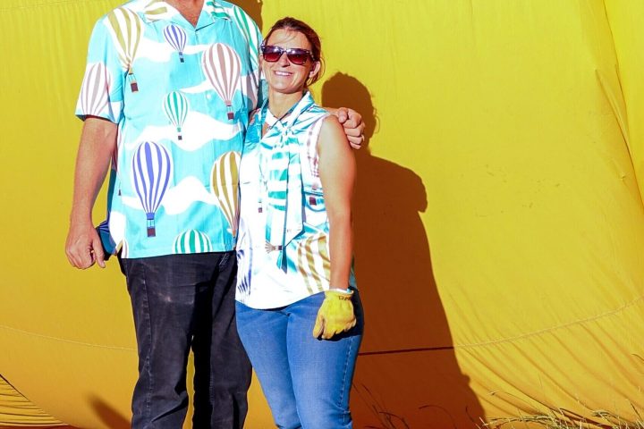married couple posing for the camera in front of pagosa adventure's hot air balloon in pagosa springs, colorado