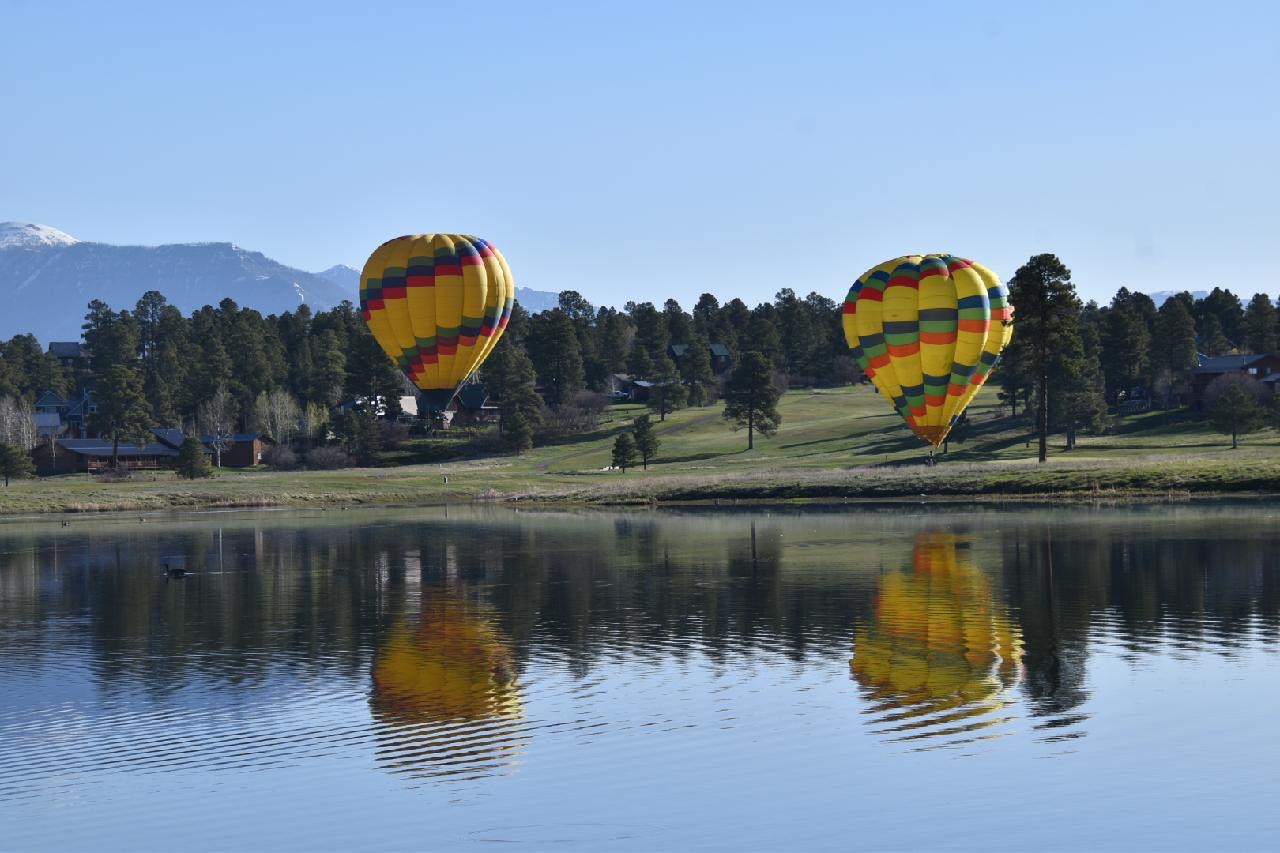 a large balloon in the sky over a body of water