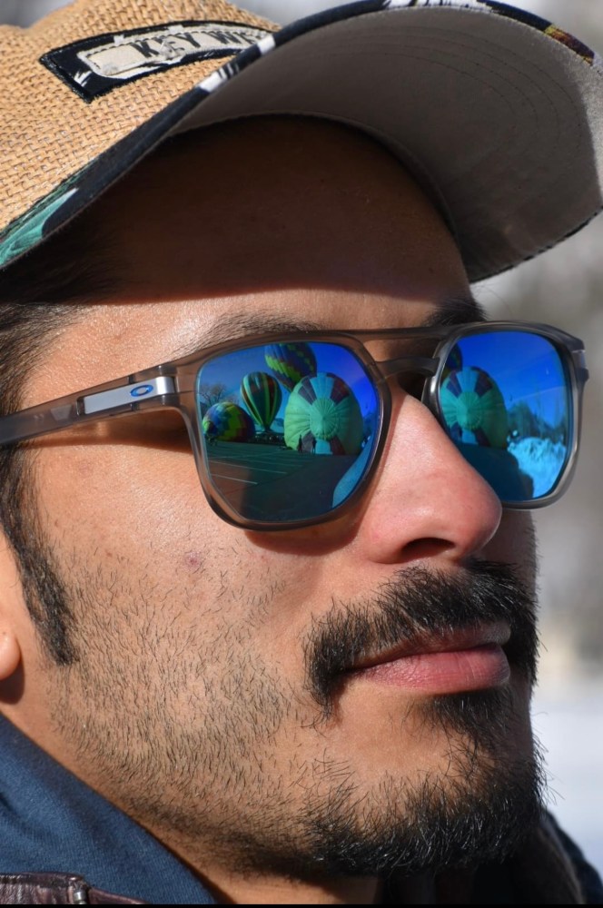 a close up of a man wearing a hat and sunglasses