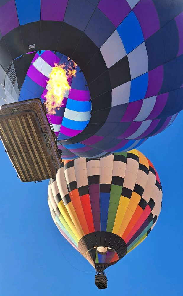 Two balloons side by side in the sky