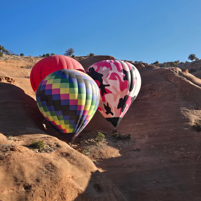 a colorful kite sitting on top of a sandy beach