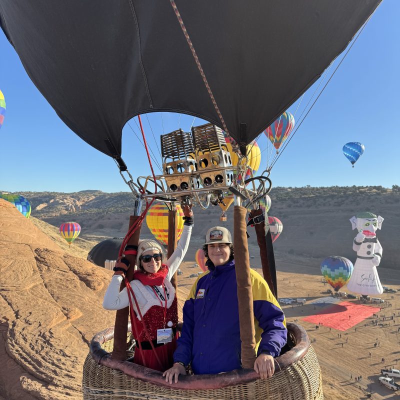 a group of people flying kites on a beach
