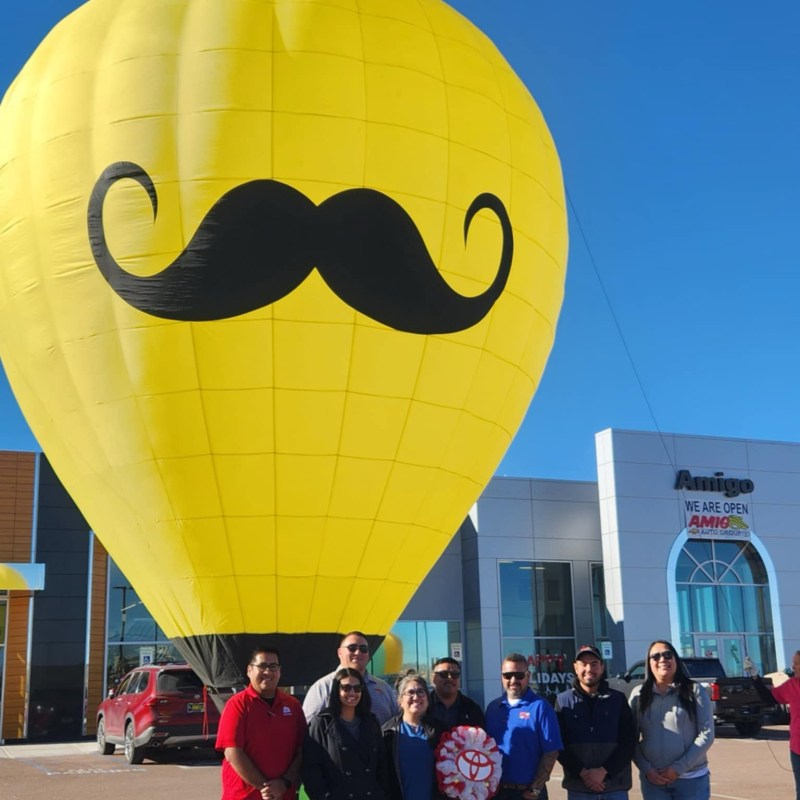 a group of people standing in front of a large balloon in the sky