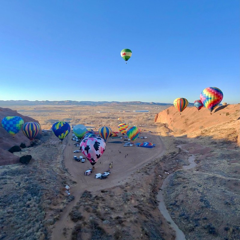 a group of people flying kites on a beach