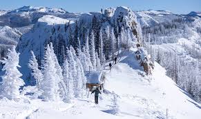 a man riding on top of a snow covered mountain