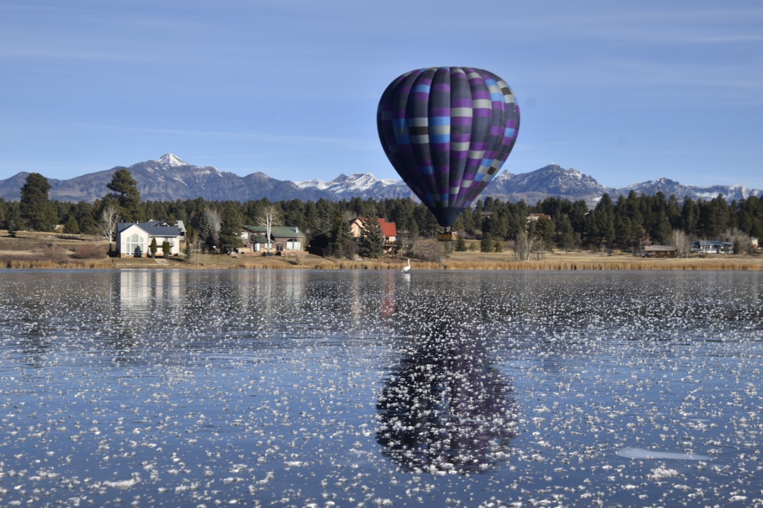 a group of people flying kites in a large body of water