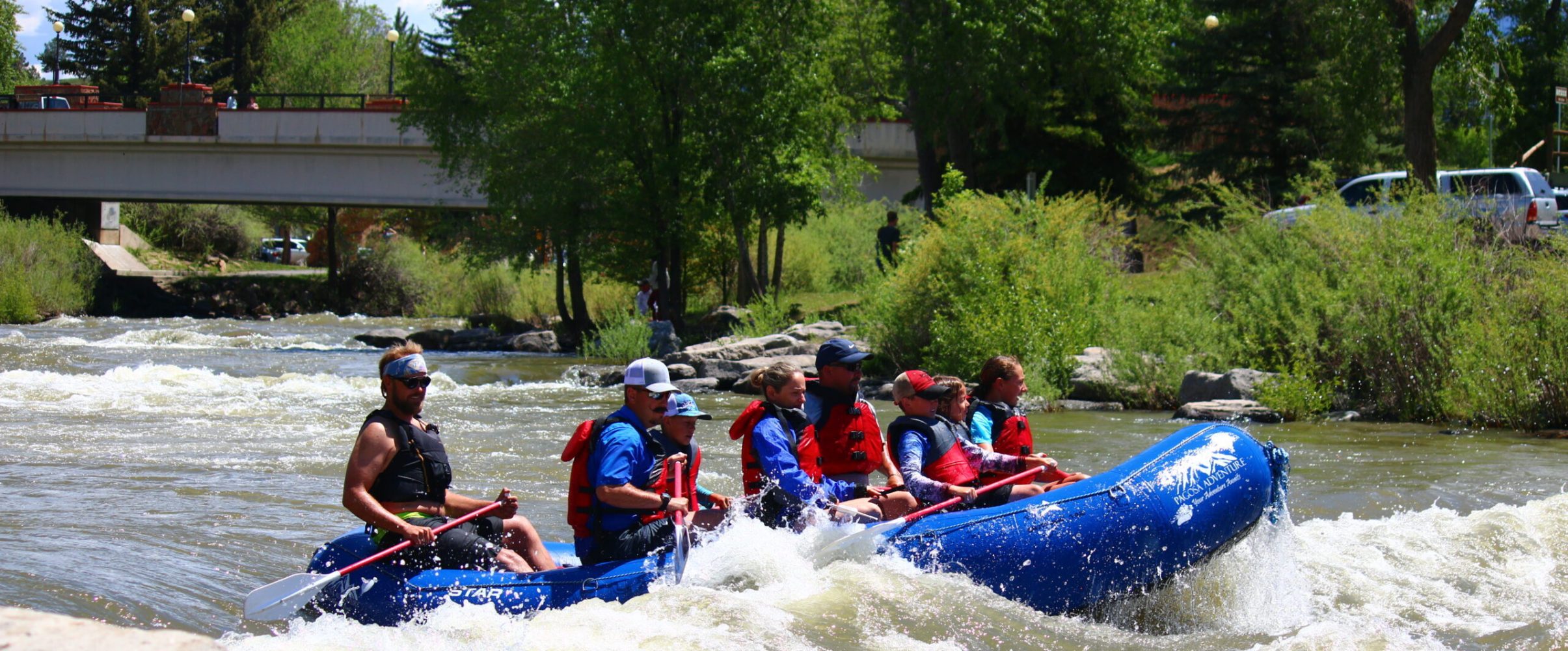 a group of people riding on the back of a boat in the water