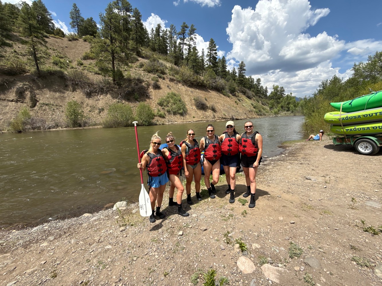 a group of people standing next to a river